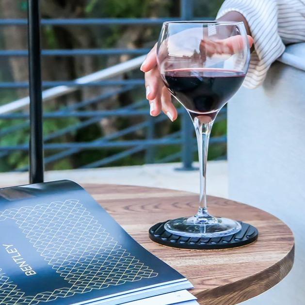 AL 3 Coaster and glossy magazine on AL 2 table top. Glass of red wine resting on the AL 3 coaster.